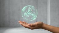 Hand holding glowing green holographic sphere with health and wellness icons including heart, hand, and medical symbols for healthcare technology concepts.