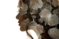 Young woman with white roses in hair creating romantic bridal portrait with soft lighting and floral arrangement for wedding photography and beauty concepts.