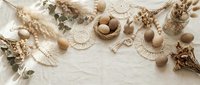 Natural Easter decoration with brown eggs, dried flowers, wheat ears and woven elements on white wooden background for spring holiday design.