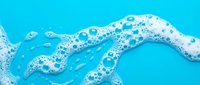 Dynamic blue water wave with white foam bubbles and splashes creating refreshing liquid motion for beverage advertising and summer campaigns.