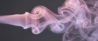 Soft pink and purple smoke swirls gracefully against a dark gray background, creating an ethereal, flowing abstract composition for creative projects.