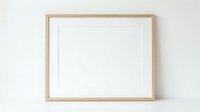 Empty wooden picture frame with white mat on neutral wall ready for artwork display and home decor projects.