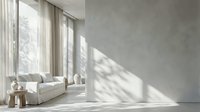 Modern minimalist living room interior with white sofa, natural sunlight streaming through large windows creating geometric shadows on concrete wall.
