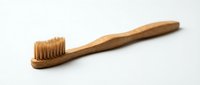 Natural bamboo toothbrush with soft bristles on white background, eco-friendly dental hygiene product for sustainable oral care and zero waste lifestyle.
