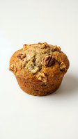 Freshly baked muffin with pecan and apple pieces throughout, perfect for bakery, food photography, breakfast menus, and culinary websites.