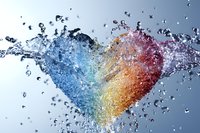 Heart shape formed by colorful water splash with droplets frozen in motion against light background, expressing love and fluidity in dynamic composition.