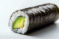 Fresh avocado and rice wrapped in crisp nori seaweed roll on white background, macro view showing texture and layers of traditional Japanese cuisine.