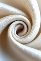 Elegant spiral fold of cream white fabric creating soft swirling pattern with visible textile texture, suitable for fashion and interior design backgrounds.