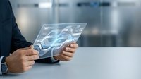 Businessman holding transparent tablet displaying digital wave data visualization in modern office environment for technology and business analytics concepts.