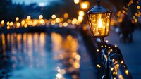 Evening street lamp glowing warmly beside a canal with bokeh lights reflecting on water, creating atmospheric urban ambiance for design and editorial projects.