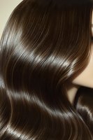 Close-up of glossy brown hair with smooth, silky texture and natural wave pattern showing healthy shine and professional salon styling results.