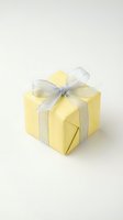 Yellow gift box with silver ribbon bow isolated on white background for holiday celebrations and special occasions.