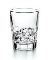 Crystal clear whiskey glass with ice cubes on white background, faceted design shows reflective surfaces and transparency, suitable for beverage advertising.