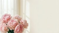 Soft pink carnation flowers bouquet on neutral beige background with natural window light creating elegant feminine floral arrangement for home decor.