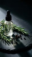 Glass dropper bottle with rosemary essential oil and fresh herbs on dark wooden surface for natural skincare and aromatherapy treatments.