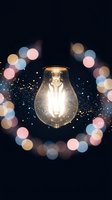 Glowing light bulb surrounded by colorful bokeh lights and sparkling particles on dark background for creative inspiration and innovation concepts.