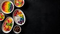 Colorful rainbow fruit and vegetable bowls arranged on dark background with copy space for healthy eating and nutrition concepts.