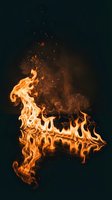 Dramatic orange flames with glowing sparks rising against dark background for energy, power and heat concepts in advertising and design projects.