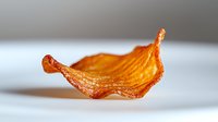 Crispy golden potato chip with curled edges isolated on white background, showcasing texture and natural ridges in macro photography detail.