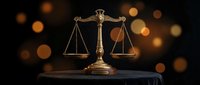 Golden scales of justice on dark surface with warm bokeh lights background symbolizing law, legal system, and judicial balance in courtroom setting.