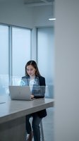 Young Asian businesswoman using laptop with holographic cloud computing interface in modern office environment for digital transformation concepts.