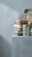 Sustainable zero waste lifestyle concept with reusable containers, lunch boxes and eco-friendly packaging on minimalist concrete surface.