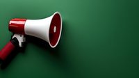 Red and white megaphone on green background with dramatic lighting and copy space, isolated for advertising and announcement concepts.
