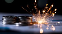 Stacked silver coins with bright sparks and glowing embers against dark background, symbolizing financial growth and investment potential. Creative finance concept.
