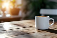 White coffee cup on wooden table with morning sunlight casting shadows through window, creating cozy atmosphere for cafe or home interior design.