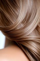 Smooth flowing blonde hair strands with natural shine and wave pattern, showcasing healthy hair texture and professional styling results for beauty and salon marketing.