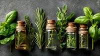 Fresh aromatic herbs and small glass bottles with essential oils on dark background, culinary ingredients for cooking and aromatherapy.
