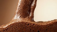 Close-up of textured brown skin with water droplets and natural moisture, suitable for skincare, cosmetics, and wellness marketing materials.