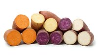 Fresh colorful sweet potato varieties sliced showing orange purple and white flesh isolated on white background for healthy cooking and nutrition.