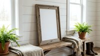 Rustic wooden frame mockup leaning on a farmhouse bench with ferns, cozy blankets, and boots in a bright shiplap interior.