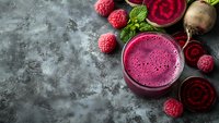 Fresh beetroot raspberry smoothie with mint leaves on dark stone background, healthy detox drink for wellness and nutrition lifestyle.