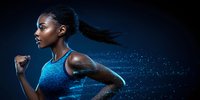 Athletic African American woman running with determination in blue sportswear against dark background with motion effect and sweat droplets glowing.