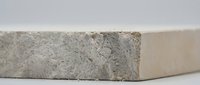 Concrete block with rough textured surface showing natural wear and weathering patterns on neutral background for construction projects.