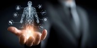 Digital hologram of human skeleton and organ systems floating above businessman's hand against dark background with medical icons.