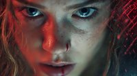 Young woman with piercing blue eyes and freckled skin illuminated by dramatic red and blue lighting creating intense cinematic portrait with moody atmosphere.