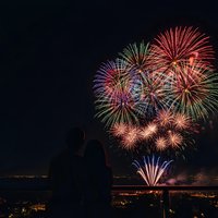 Spectacular fireworks display bursting with colorful explosions over city skyline at night creating festive celebration atmosphere for holidays and events.