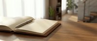 Open notebook with blank pages on wooden desk with pen, suitable for writing, journaling, education, and office design projects.