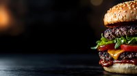 Juicy double cheeseburger with melted cheese, fresh vegetables and sesame bun on dark background with copy space. Close up view of gourmet burger.