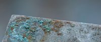 Weathered copper surface with natural patina oxidation showing turquoise and rust colored corrosion patterns on aged metal texture for industrial design projects.