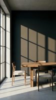 Minimalist dining room with wooden table and chairs bathed in natural light from large window, casting geometric shadows on dark wall, modern interior design.