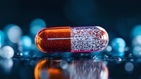 Glowing orange and silver medical capsule on reflective surface with blue bokeh background, pharmaceutical macro photography for healthcare concept.