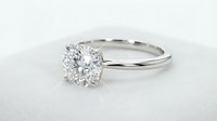 Classic solitaire diamond engagement ring with round brilliant cut stone in white gold setting on neutral background for jewelry design.