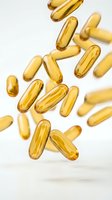 Golden vitamin capsules floating and falling on white background for health and wellness supplement advertising.