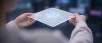 Professional businesswoman holding transparent digital interface panel with holographic data visualization in modern office environment for technology presentations.