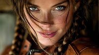 Young Caucasian woman with braided hair and freckles looking at camera with intense blue eyes in warm golden lighting for portrait photography.