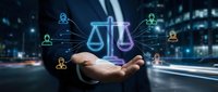 Digital justice scales hologram floating above open palm with connected user icons representing legal technology and online law services.